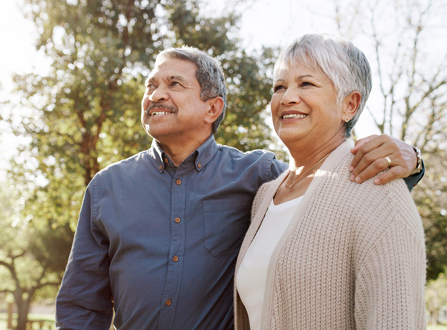 A senior couple pose for a photo oustide