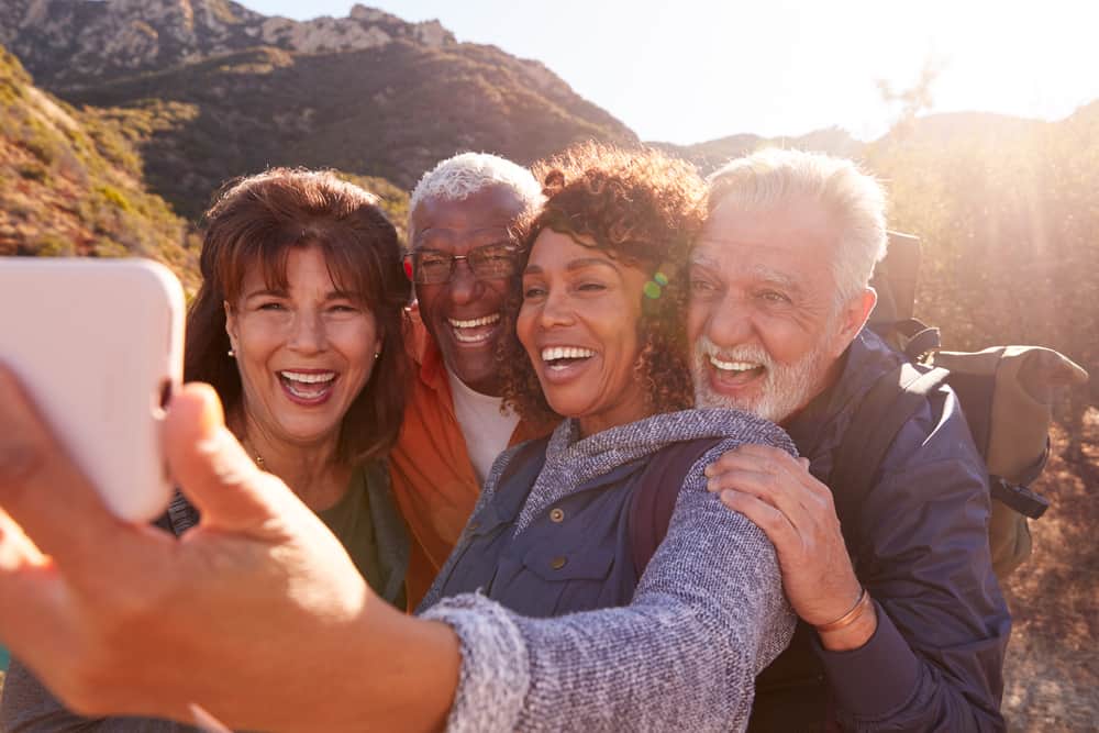 A group of seniors take a selfie during a hiking trip