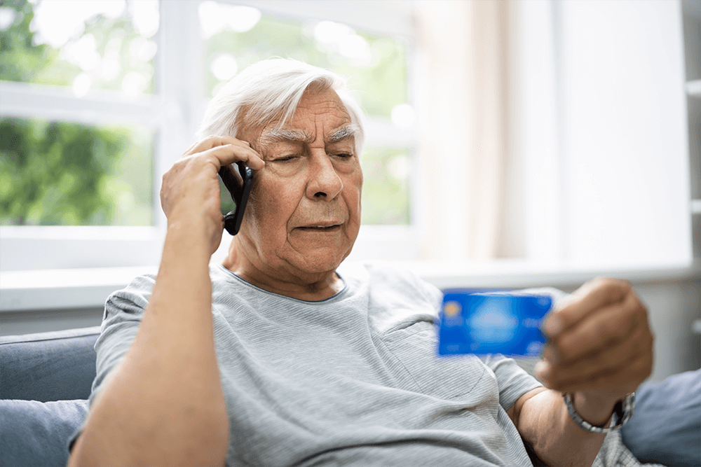 Man on telephone holding credit card