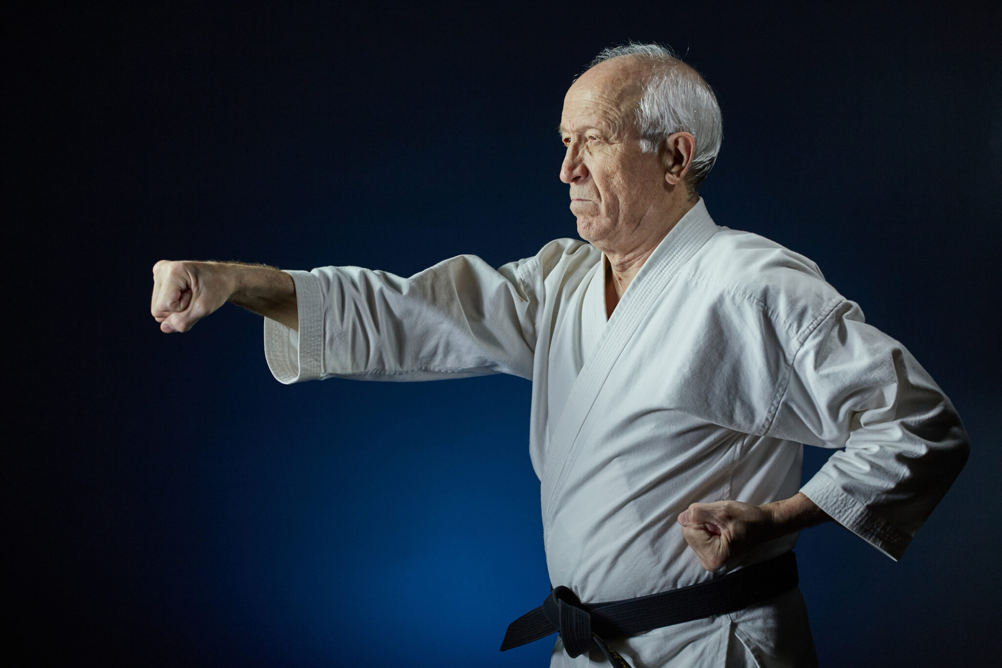 On a blue background, an old man athlete beats a punch arm