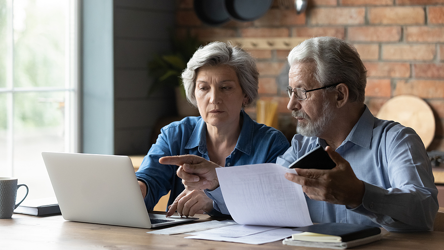 Senior couple sitting down and researching entrance fee.