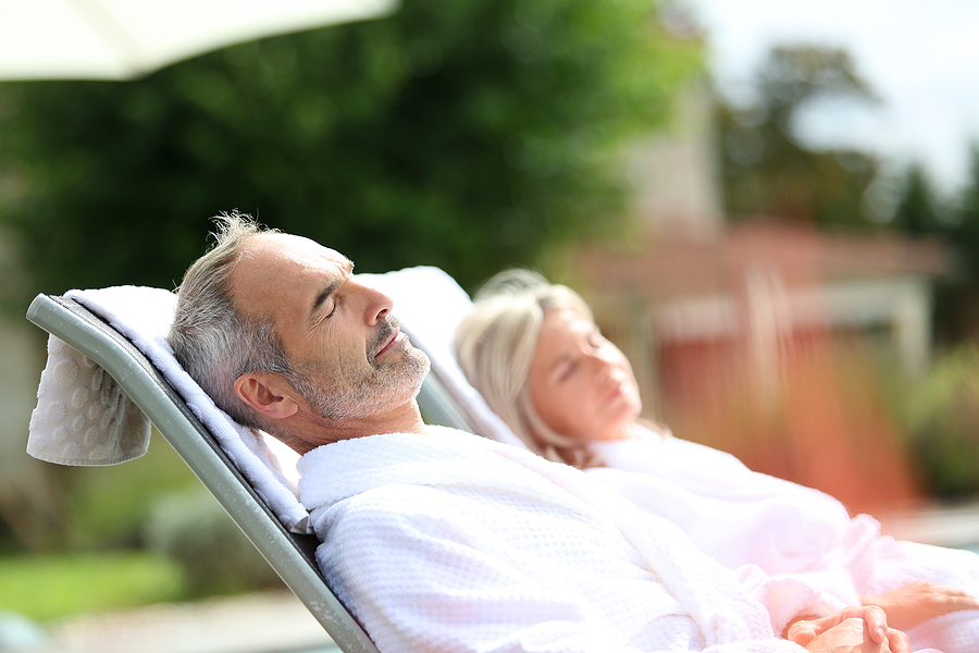 Senior couple relaxing in long chairs outdoors