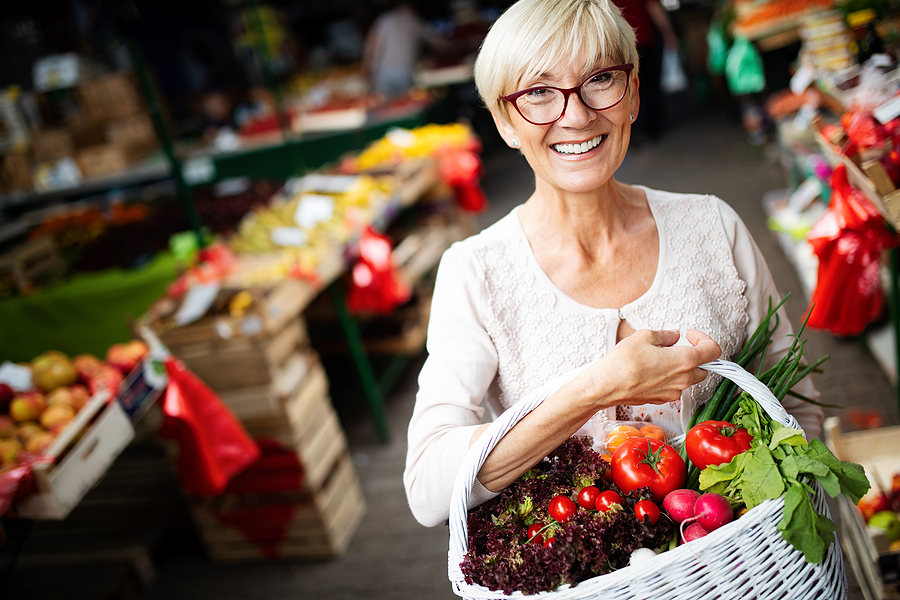 A senior woman shops at a farmers market.