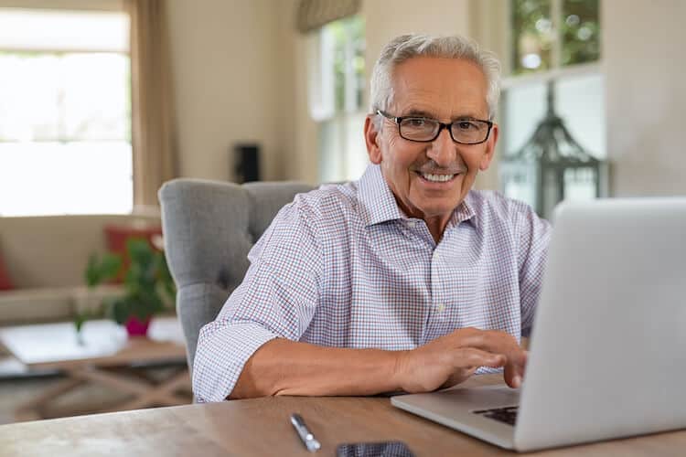A man at his laptop looking for ways to save money for retirement
