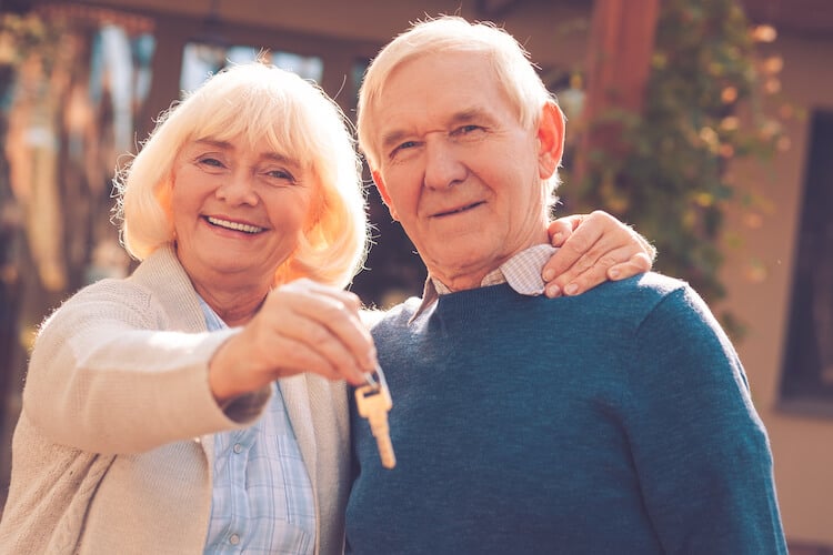 Senior couple moving and holding new key.