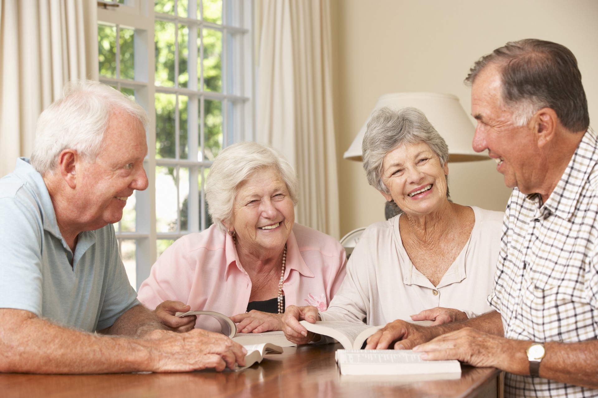 Happy group of seniors reading books together