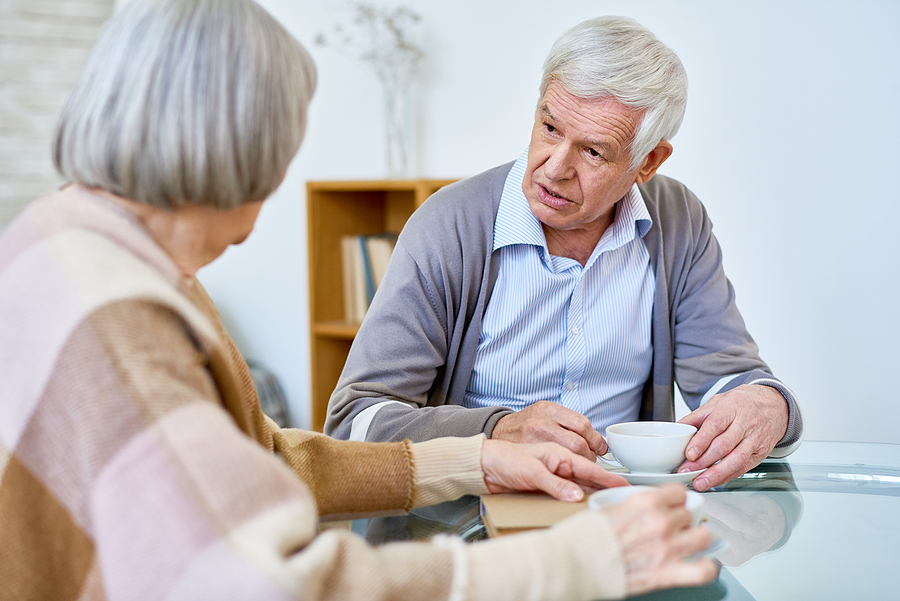 A senior man and a woman talking over morning coffee