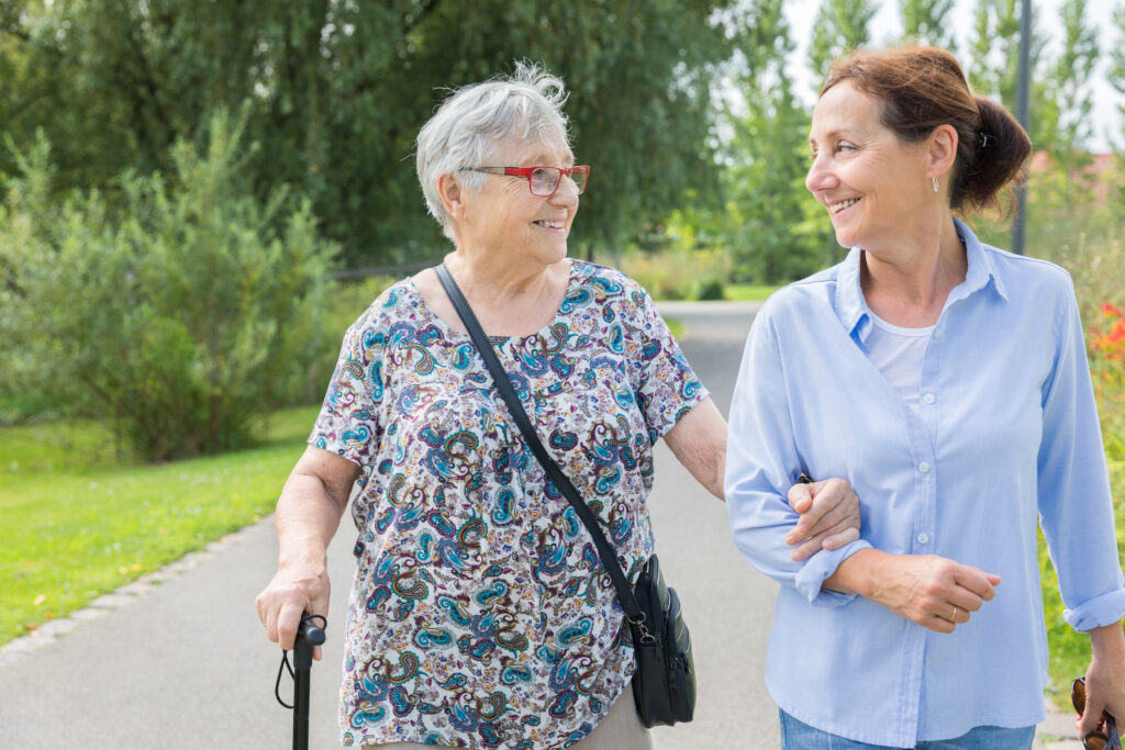 Caretaker Helping Senior Woman Walking Outside