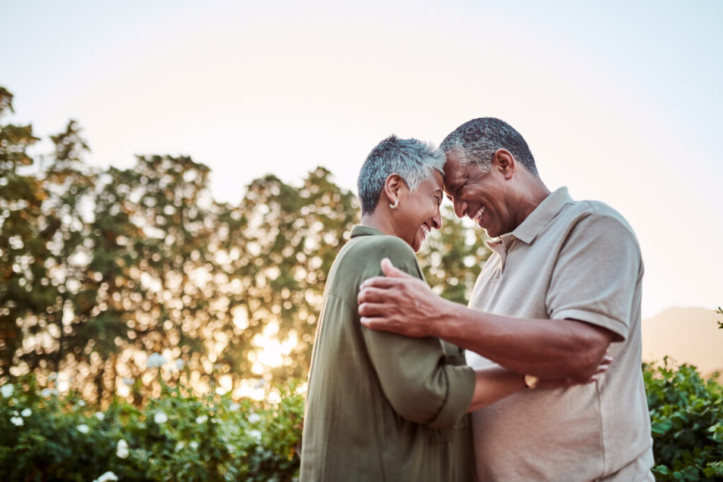 Senior Couple Smiling at One Another Outside and Hugging