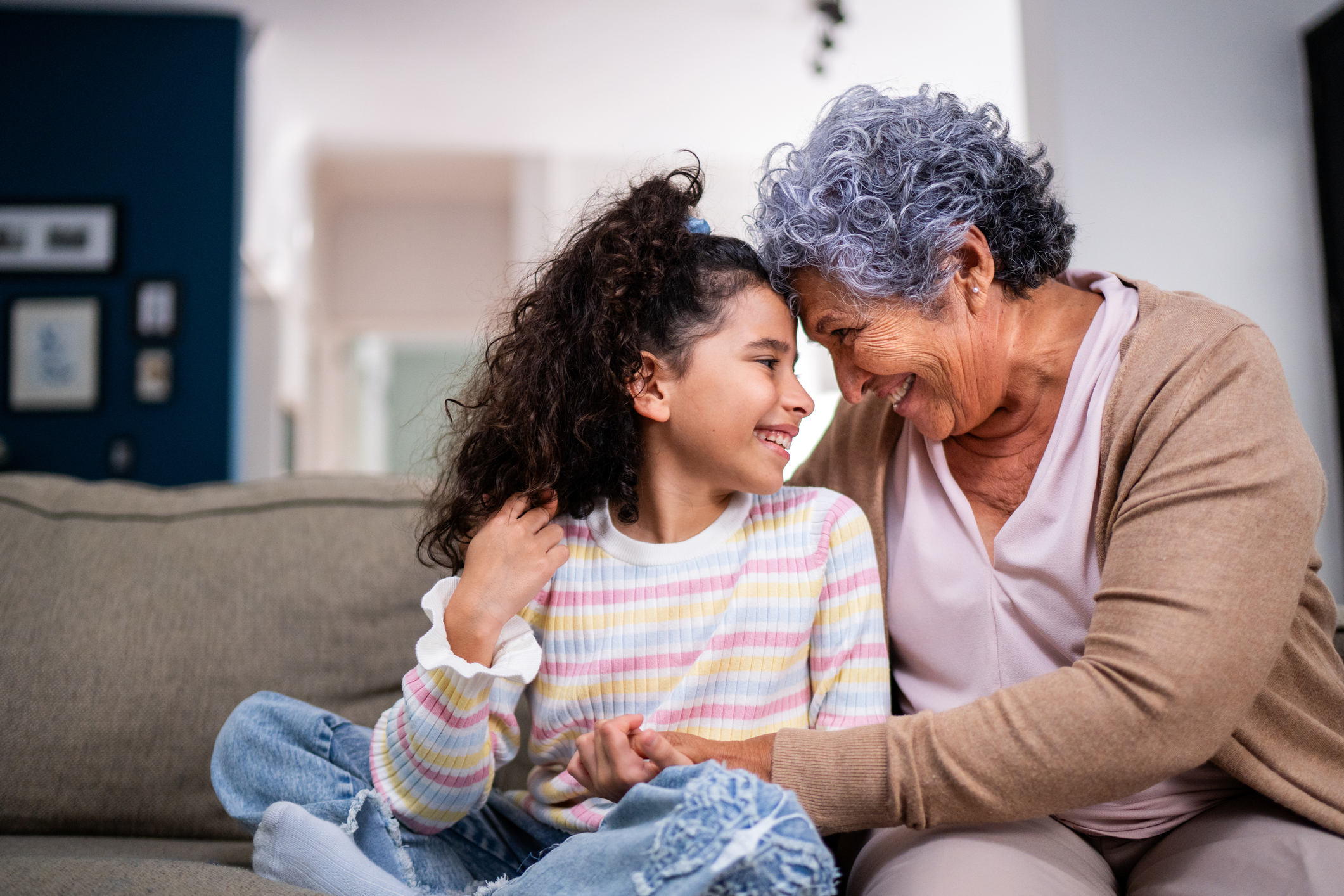 An older adult grandma and her young granddaughter hug