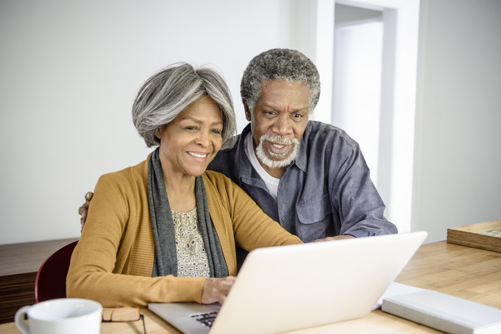 Senior Couple Looking at Computer Smiling