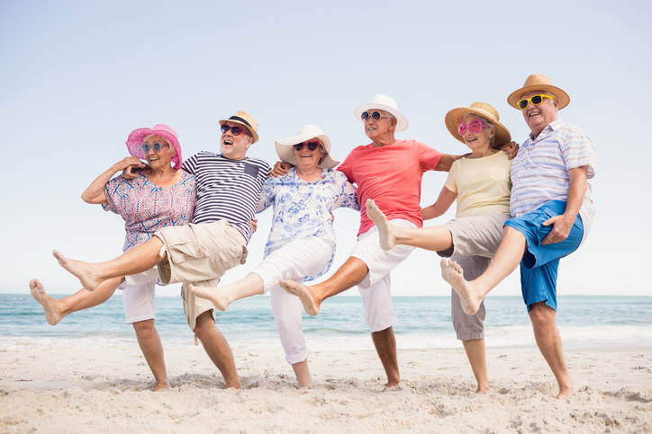 Group of Seniors Smiling and Dancing on Beach